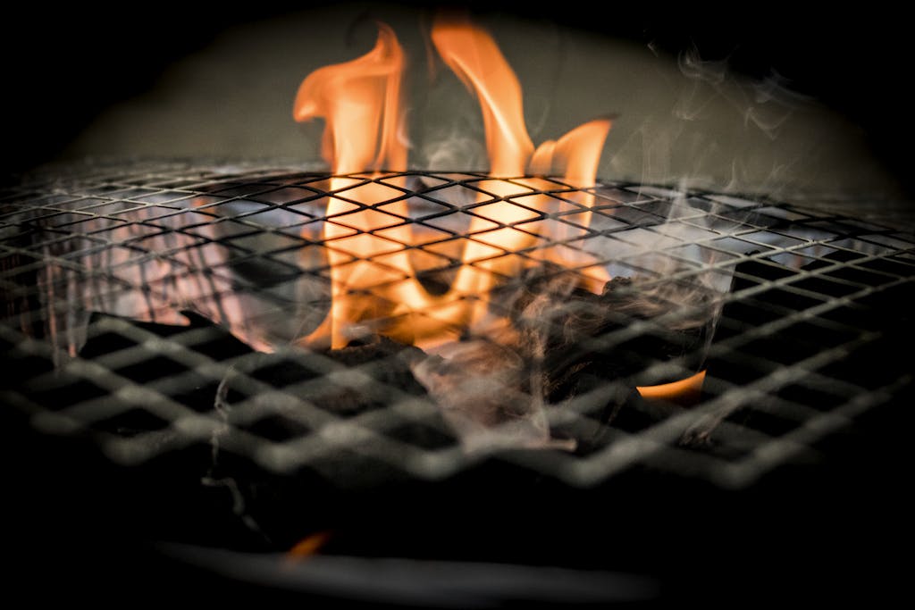 Vivid flames dance over a grill, ideal for cooking concepts and barbecue themes.